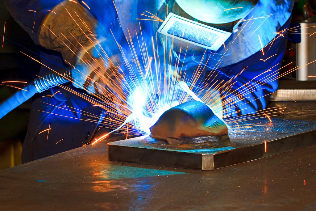 Lasser voert precisielas uit met lasspetters en beschermhelm bij TOS